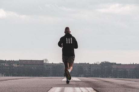 Runner hydrating with electrolyte supplement during summer outdoor workout